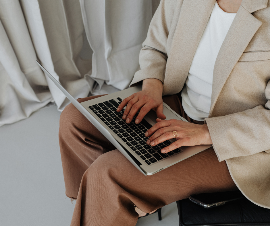 A woman typing on the computer to communicate UGC SEO strategy to her team.