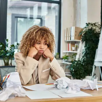 A business woman sitting at a desk wondering if SEO for the finance industry is still relevant.