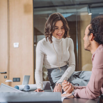 Two marketers sitting and discussing AI search optimization and how to improve websites for clients.