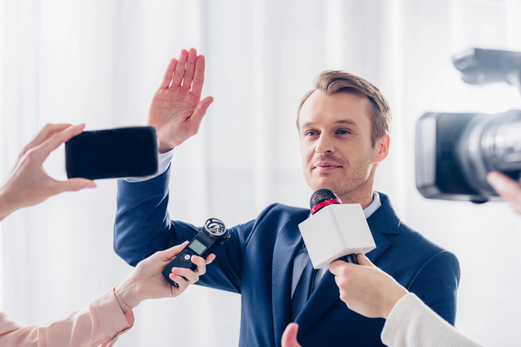A man raising his hand to be interviewed by podcasters and media showing the importance of authority in ai search optimization.