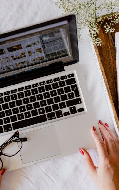 Person working on a laptop with notebooks, symbolizing a focused workspace for SEO consulting and digital marketing.